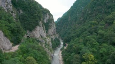 Yazın Soçi 'de nehrin altında çimen olan dağların insansız hava aracı çekimi.