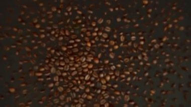 Siyah arka planda uçan kahve çekirdekleri yavaş hareket ediyor.