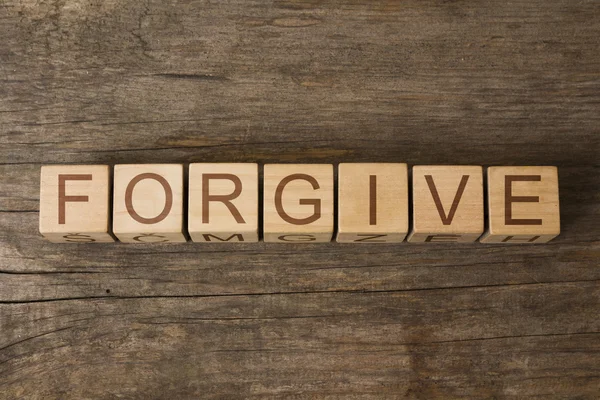 Wybaczyć słowo na drewniane kostki — Zdjęcie stockowe