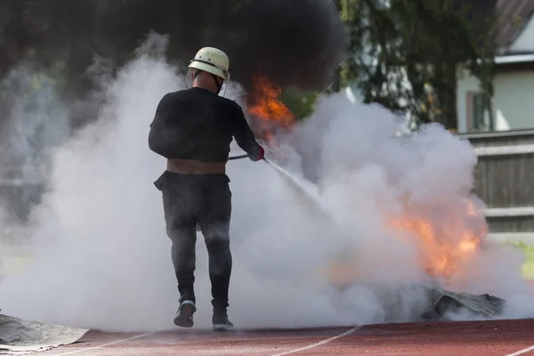 Yangın uygulanan spor itfaiye yangın söndürücü koyar — Stok fotoğraf