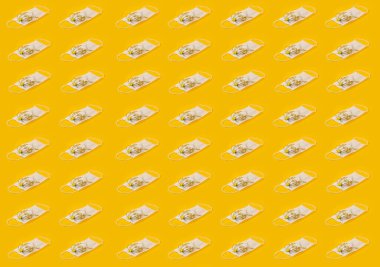 Sarı çiçekli ve sarı arkaplanlı tekrarlanan tıbbi yüz maskeleri. Corona Koruma Sağlıklı Kavram. Düzenli Desen, Düz Yat.