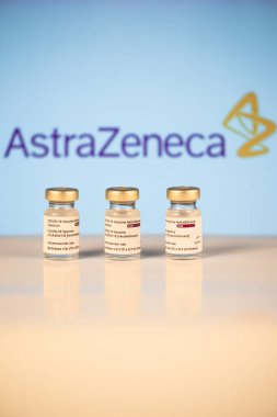 San Sebastian, Gipuzkoa, Spain; 03 February 2021.Three Covid-19 vaccine vials with astrazeneca logotype background to inject medical professionals and people at risk. SARS-CoV-2 vaccination treatment. Copy space. clipart