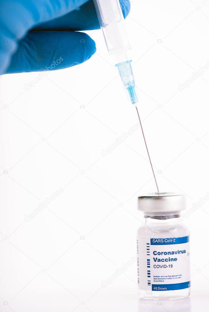 Hands with blue latex gloves syringe taking anti covid vaccine from vial