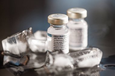 San Sebastian, Gipuzkoa, İspanya; 24 Nisan 2021. Ön planda eriyen buz küpleriyle Pfizer tarafından yapılmış iki şişe Covid aşısı. Stüdyo çekimi.
