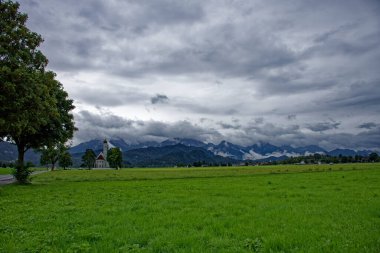 Bulutlu bir sonbahar günü Alplerin eteğindeki bir şatonun yanında. 