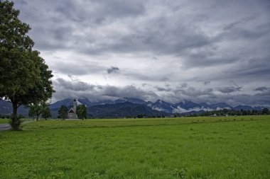 Bulutlu bir sonbahar günü Alplerin eteğindeki bir şatonun yanında.