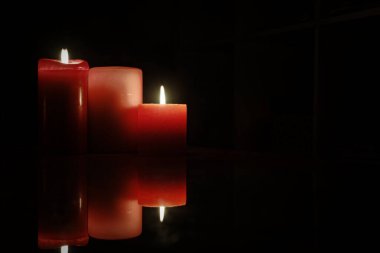  Kırmızı mumlar Karanlığı Ilık bir parıltıyla aydınlatıyor 