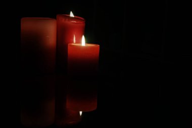  Kırmızı mumlar Karanlığı Ilık bir parıltıyla aydınlatıyor 
