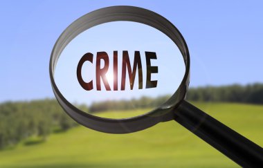 Bulanık doğa arka plan üzerinde kelime suç ile büyüteç. Suç kavramını arama