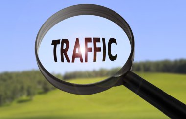 Bulanık doğa arka plan üzerinde kelime trafik ile büyüteç. Trafik konseptinde arama