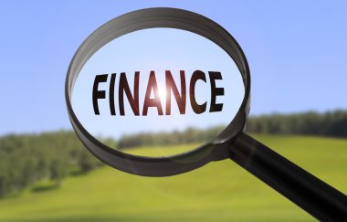 Bulanık doğa arka plan üzerinde kelime finans ile büyüteç. Finans konseptini arama