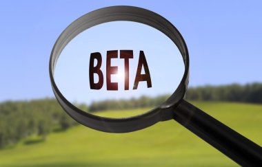 Bulanık doğa arka plan üzerinde kelime beta ile büyüteç. Beta konseptinde arama