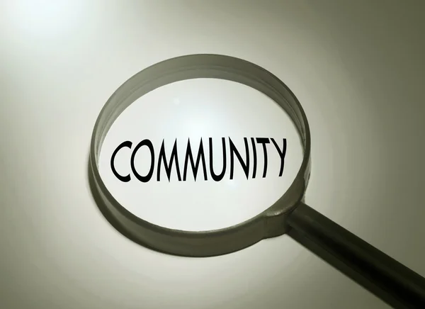 Lupa con la palabra comunidad. Buscando comunidad —  Fotos de Stock
