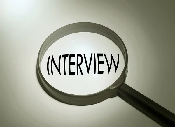 Увеличительное стекло со словом "интервью". Поиск интервью — стоковое фото