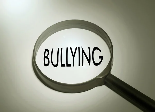 Lupa con la palabra bullying. Buscando acoso escolar — Foto de Stock