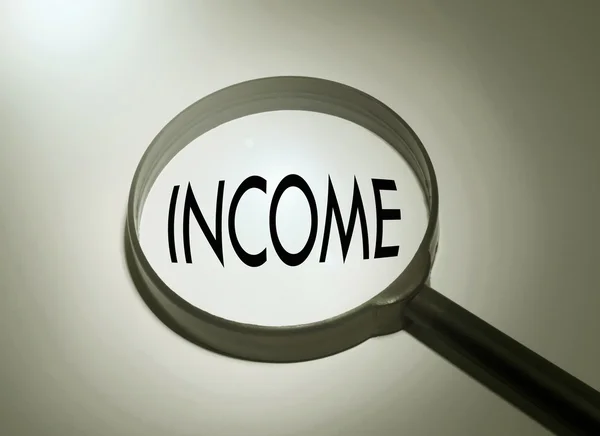 Verre grossissant avec le mot revenu. Recherche de revenus — Photo