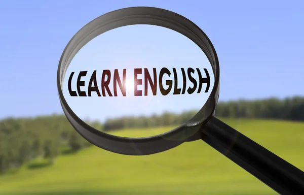 Ampliação com a palavra aprender inglês no fundo da natureza turva. Pesquisando aprender Inglês conceito — Fotografia de Stock