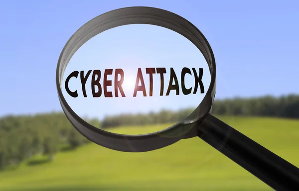 Lupe mit dem Wort Cyberangriff auf verschwommenem Naturhintergrund. Konzept für Cyber-Angriffe gesucht — Stockfoto