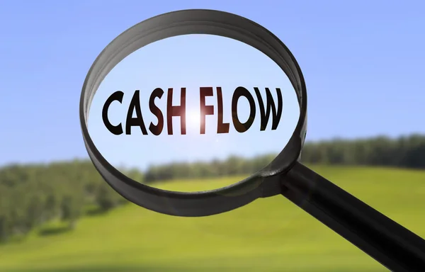 Lupe mit dem Wort Cash Flow auf verschwommenem Naturhintergrund. Cashflow-Konzept suchen — Stockfoto