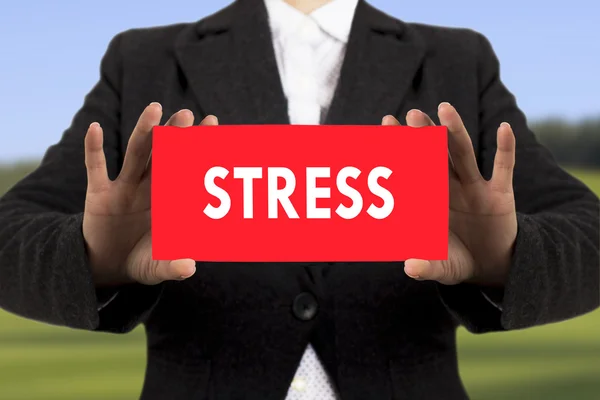 Empresária em uma jaqueta preta mostra um cartão com o estresse inscrição. Foco seletivo . — Fotografia de Stock