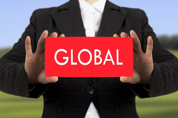 Businesswoman in a black jacket shows a card with the inscription global. Selective focus. — Stock Photo, Image