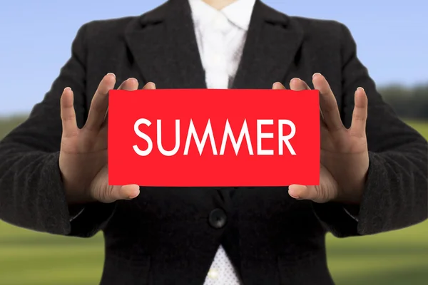 Podnikatelka v černém kabátku ukazuje kartu s nápisem léto. Selektivní fokus. — Stock fotografie