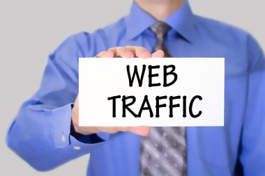Businessman in blue shirt and gray tie shows a card with the inscription web traffic