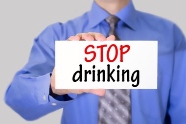 Businessman in blue shirt and gray tie shows a card with the inscription stop drinking.