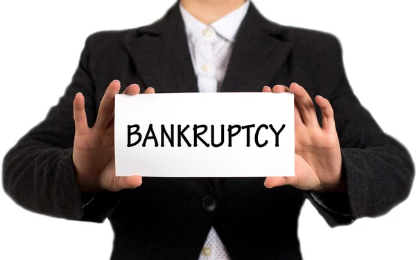 Businesswoman in a black jacket and a white shirt shows a card with the inscription bankruptcy — Stockfoto