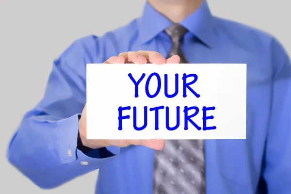 Businessman in blue shirt and gray tie shows a card with the inscription your future — Stock Photo, Image