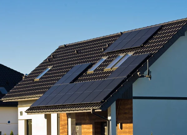 Çatı katındaki özel evin çatısındaki modern siyah hücreli güneş panelleri. Ev kavramı için yenilenebilir enerji.