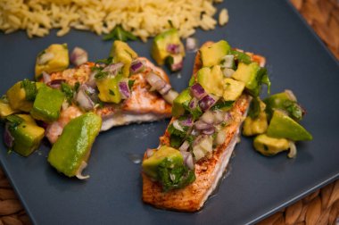 Avokado, pirinç, limon ve sebzeli güzel bir kızarmış somon.. 