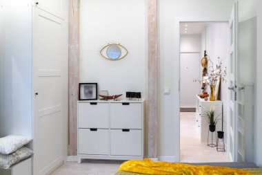 Yatak odası yatak odası, modern ayna ve çekmeceler, dolabı olan bir oturma odası ve eski evin tavan arasındaki küçük, samimi bir stüdyo dairede giriş kapısı olan bir koridor.