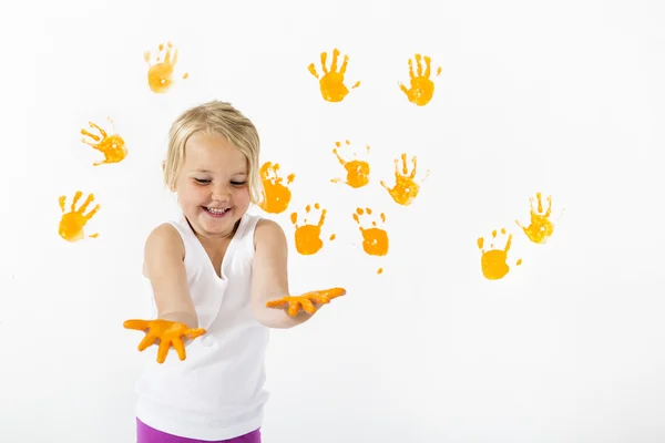 Menina pintando uma parede com cor laranja — Fotografia de Stock