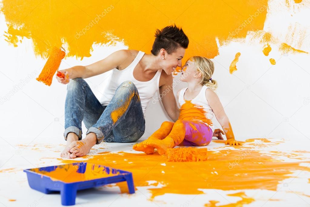 Mother and daughter painting a wall at home