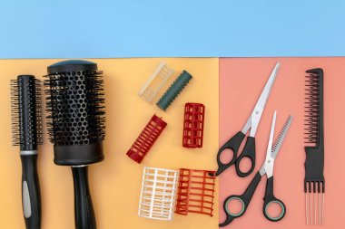 Renkli arka planda kopya alanı olan profesyonel kuaför aletleri. Kuaför ekipmanları hazır. Makas, fırça, tarak, bigudiler, düz üst görünüm.
