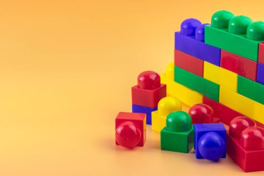 Sarı arkaplanda izole edilmiş renkli plastik bloklar