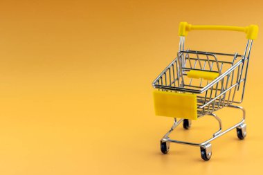 Sarı arka planda izole edilmiş alışveriş arabaları. Satışlar ve terfiler. Market ve süpermarket. Alışverişe git.