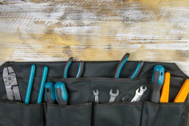 Ahşap arka planda iş aletleri olan çilingir kemeri. Hizmet kavramları. Yukarıdan görüntüle.