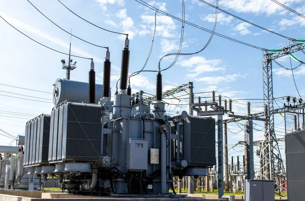 Mavi gökyüzüne karşı yüksek voltajlı trafo. Elektrik akımı yeniden dağıtım oranı