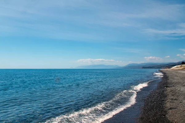 Mavi deniz, parlak güneş ve kumlu beac