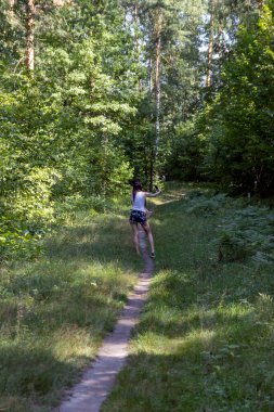 Ormanda yürü. Orman yolunda telefonu olan bir kız. Arka plan.