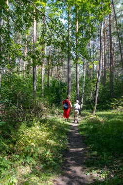 Anne ve oğlunun ormanda birlikte yürümesini dikiz aynasından izlemek..