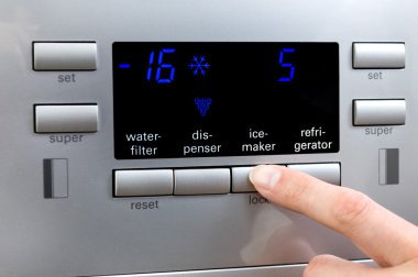 Choosing ice-maker programme at refrigerator displayer clipart