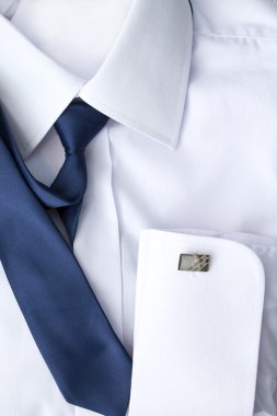 Adamın beyaz gömleği mavi kravat ve kol düğmeleri