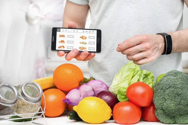 Een man winkelen online gebruikend zijn smartphone. — Stockfoto