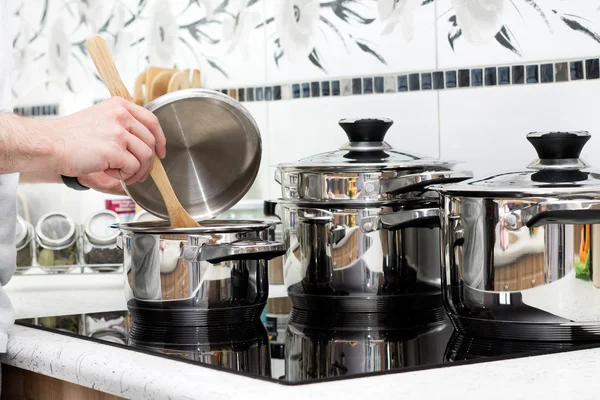 L'uomo prepara la cena sul moderno fornello a induzione — Foto Stock