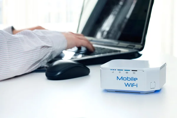 Dispositivo de roteador WiFi móvel na mesa e empresário — Fotografia de Stock