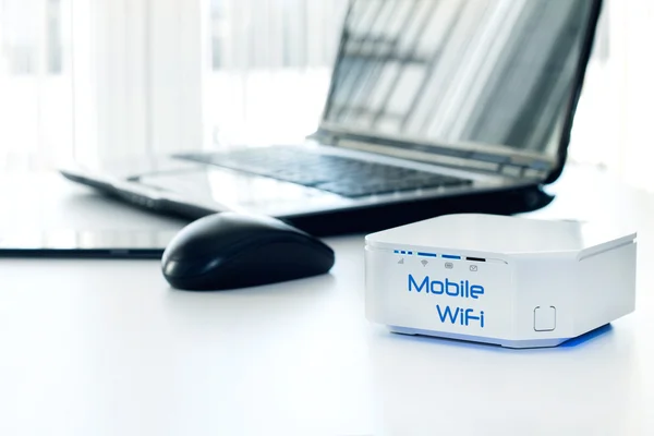 Mobile WiFi router device on the table and notebook — Stock Photo, Image