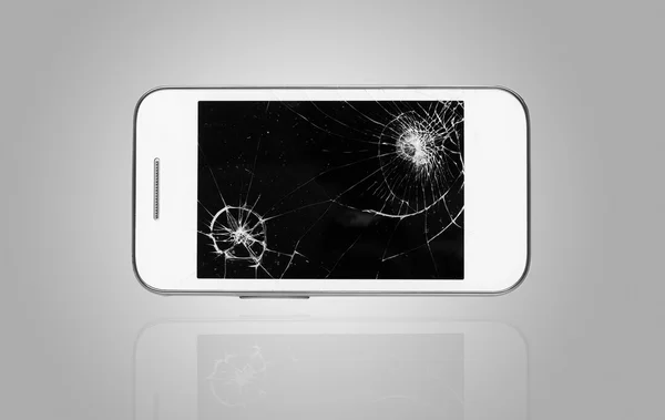 Смартфон со сломанным экраном на графическом фоне — стоковое фото